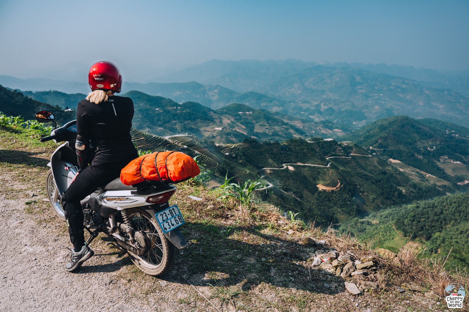 girl on a motorbike admiring a beautiful mountain landscape on Ha Giang Loop